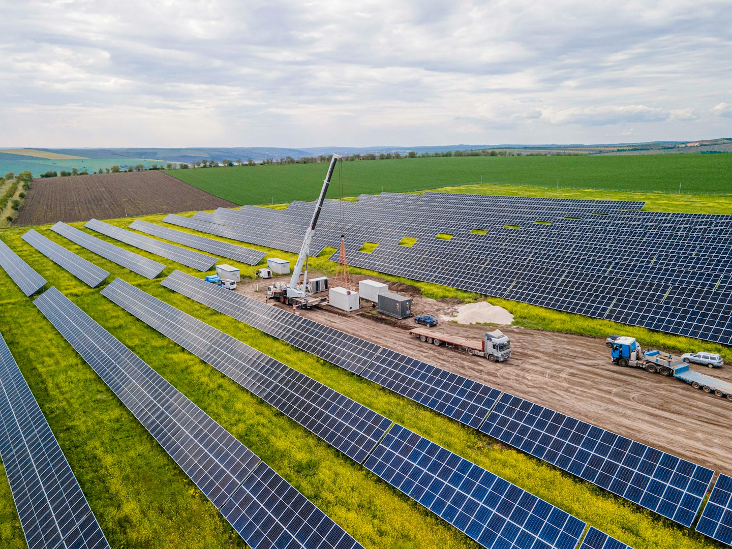 Construction equipment works on a large solar farm project.