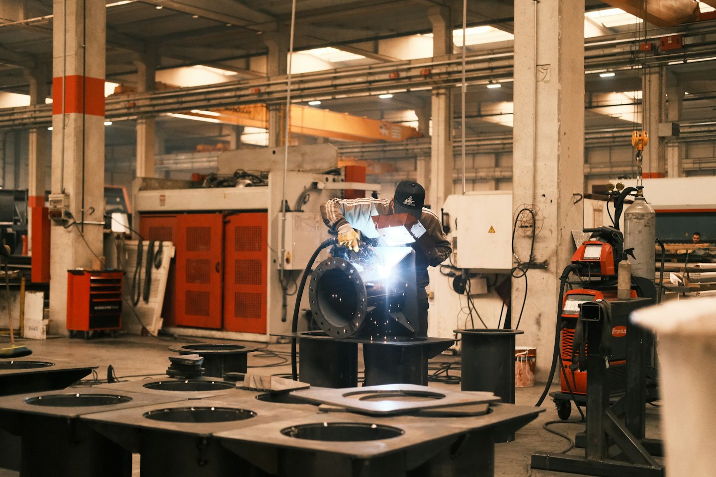 Male worker welding metal in a factory.